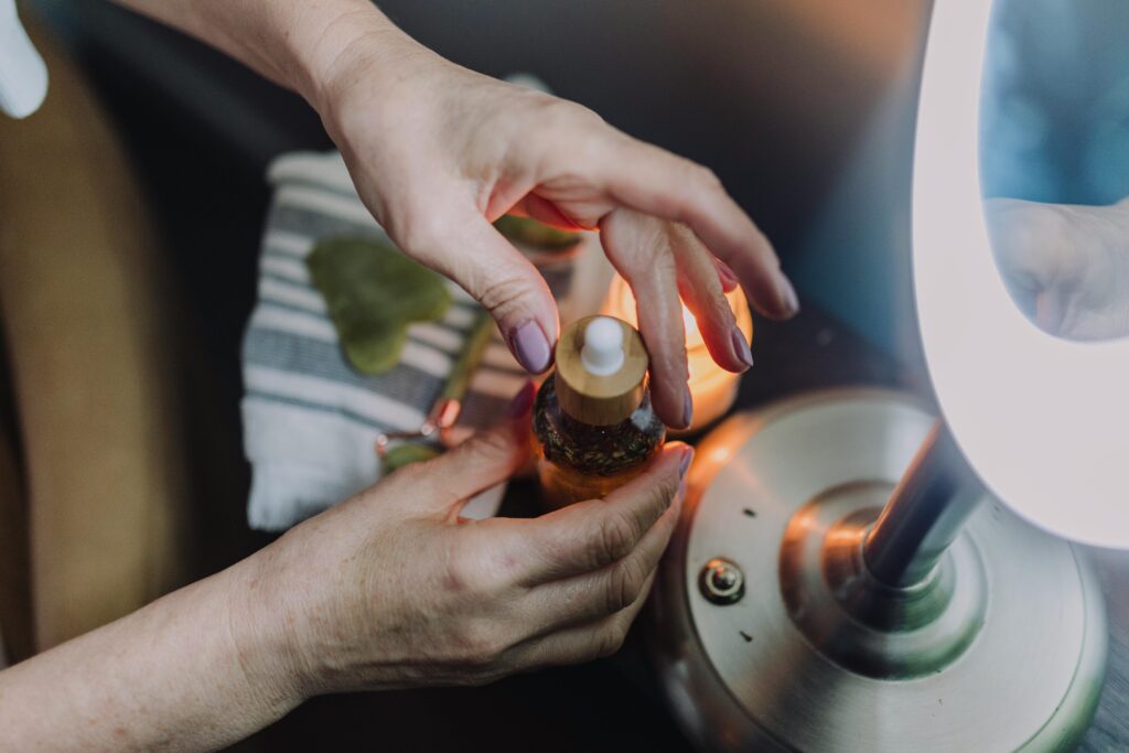 Cosmetic product bottle held by hands under soft lamp light, creating a warm atmosphere.